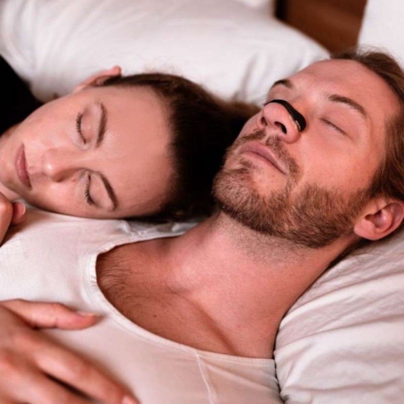 Couple sleeping, man wearing a magnetic nasal strip