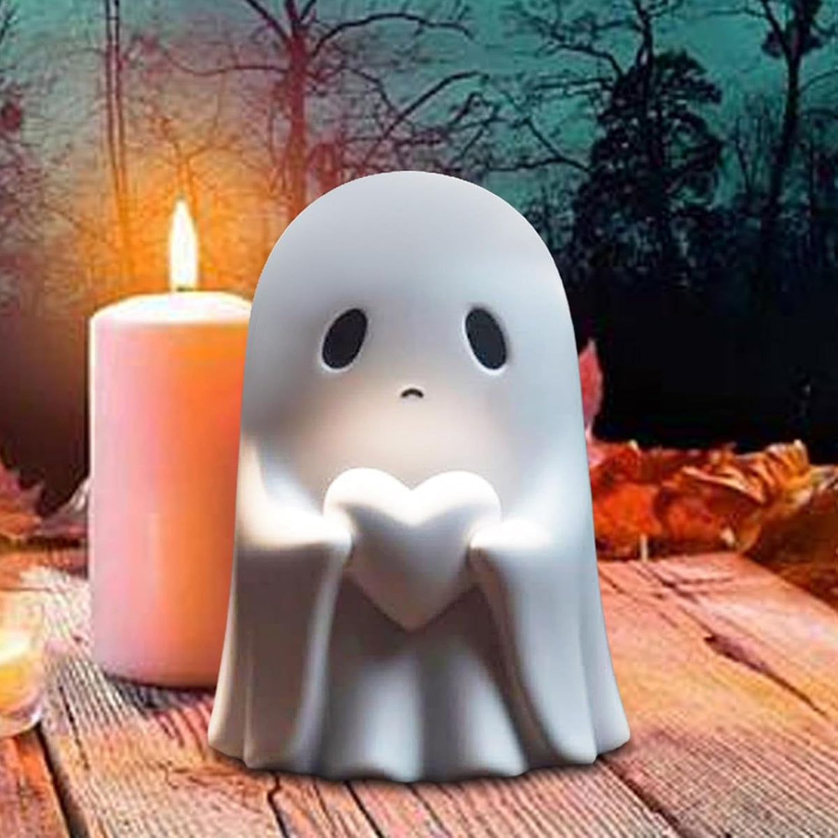 Ghost figurine with heart next to a candle