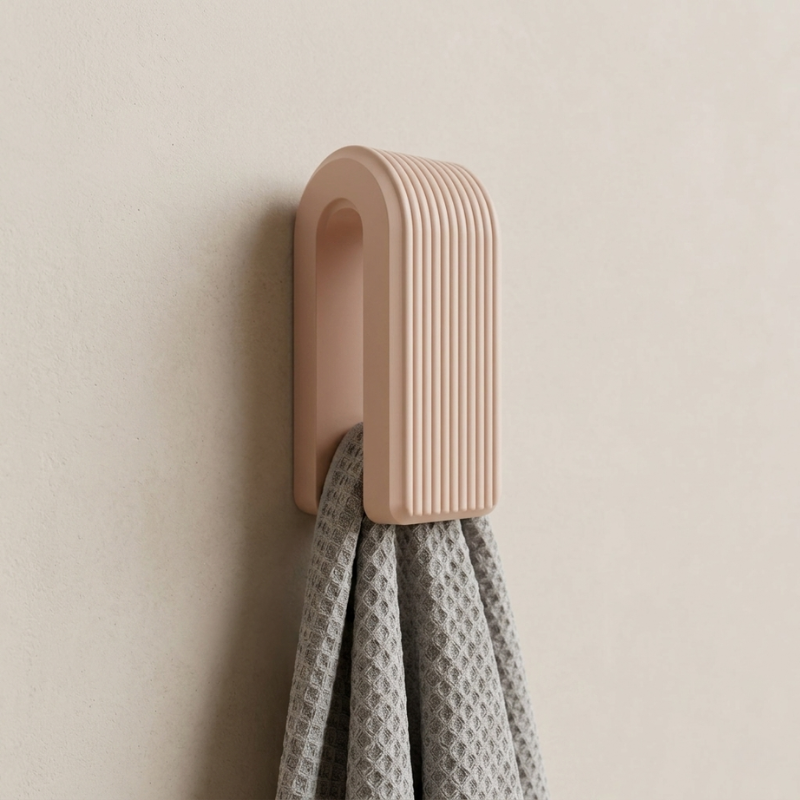 Beige wall hook with a gray towel on a beige wall