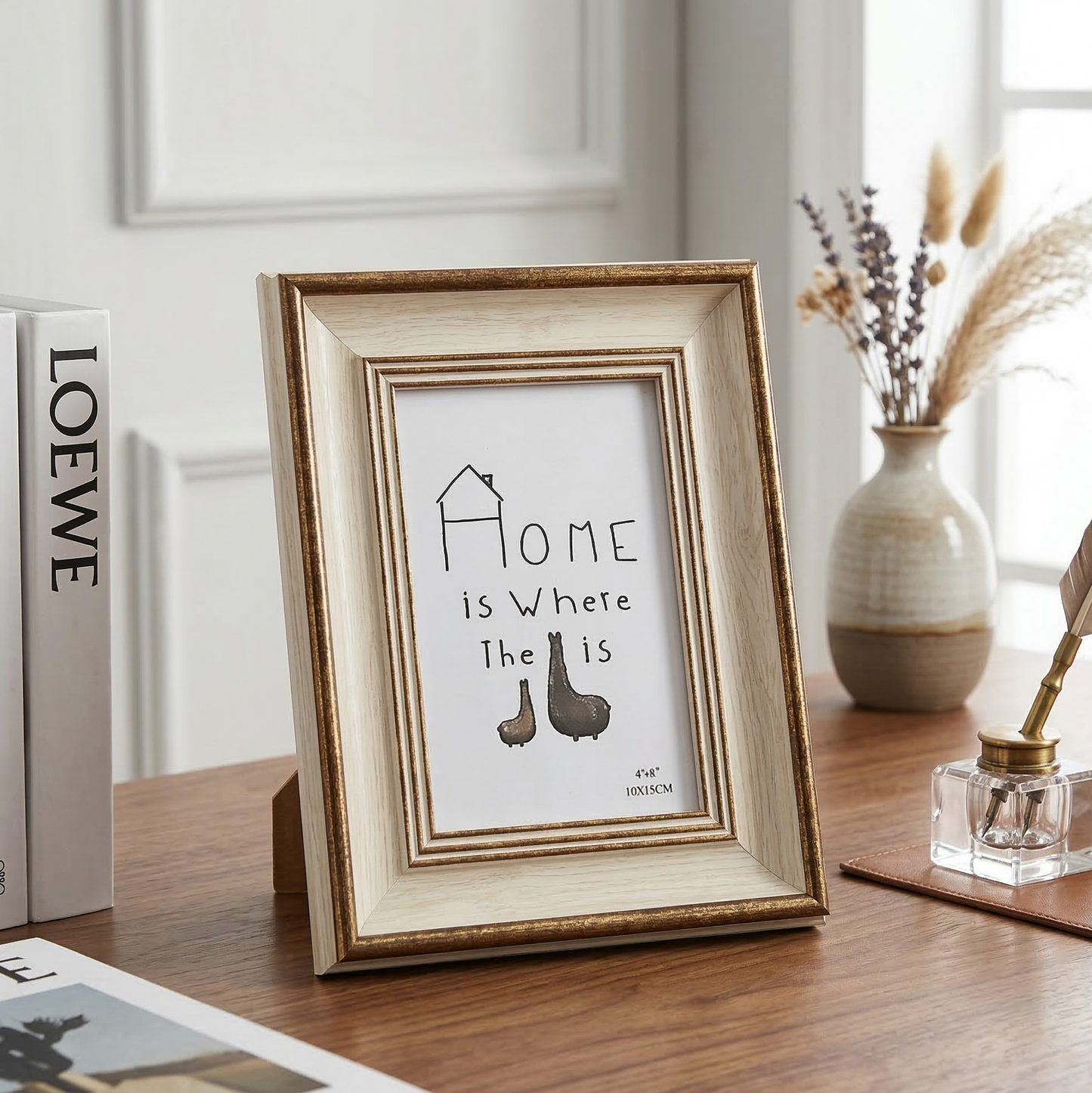 Framed print with 'Home is Where the Heart Is' quote on a wooden surface.