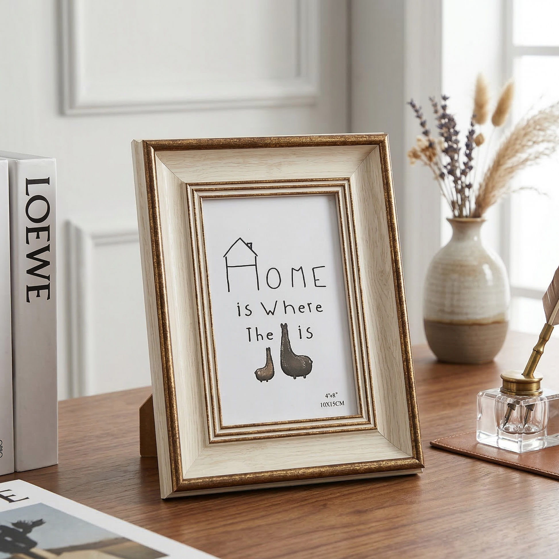 Framed print with 'Home is Where the Heart Is' quote on a wooden surface.