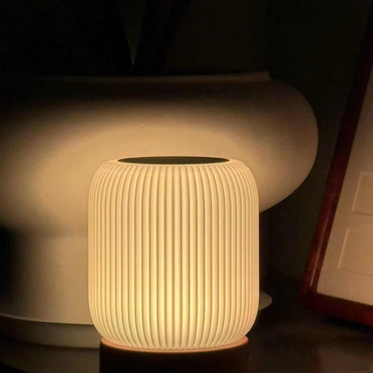 Cylindrical ceramic lamp with ribbed texture on a dark background