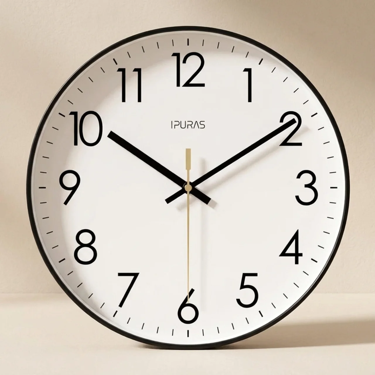 Round wall clock with black frame and white face on a beige background