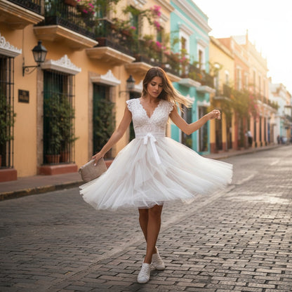 Woman in a white dress walking on a cobbled street with colorful buildings in the background