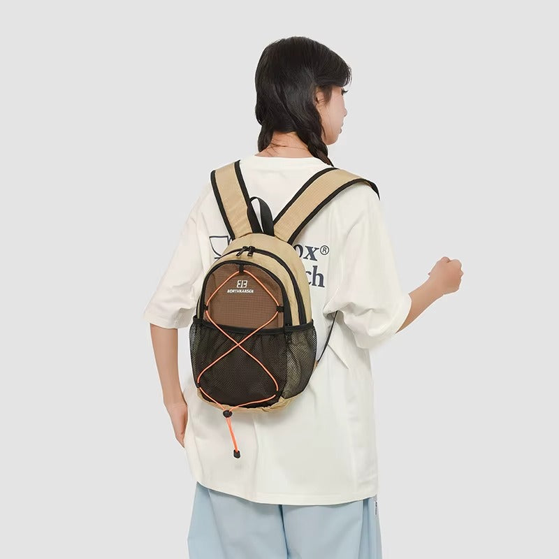 Person wearing a beige and brown backpack on a plain background