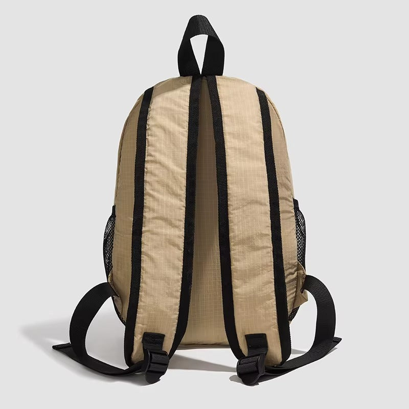 Beige backpack with black straps on a light gray background