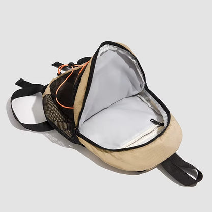 Beige and black backpack with open front pocket on a light gray background