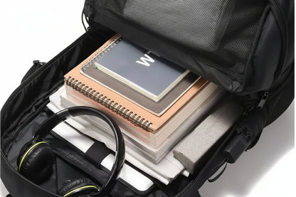 Black backpack with compartments holding a notebook, spiral-bound book, and headphones.