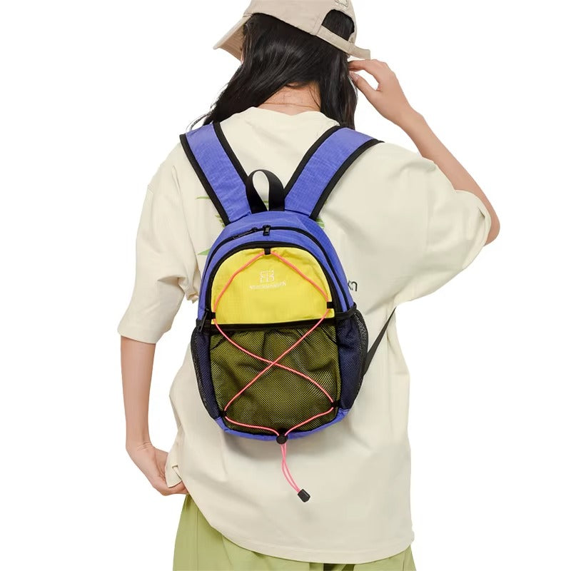 Person wearing a colorful backpack with a neutral background